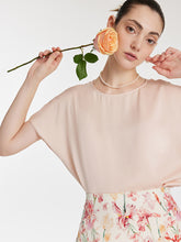 A lady wears a silk T-shirt.